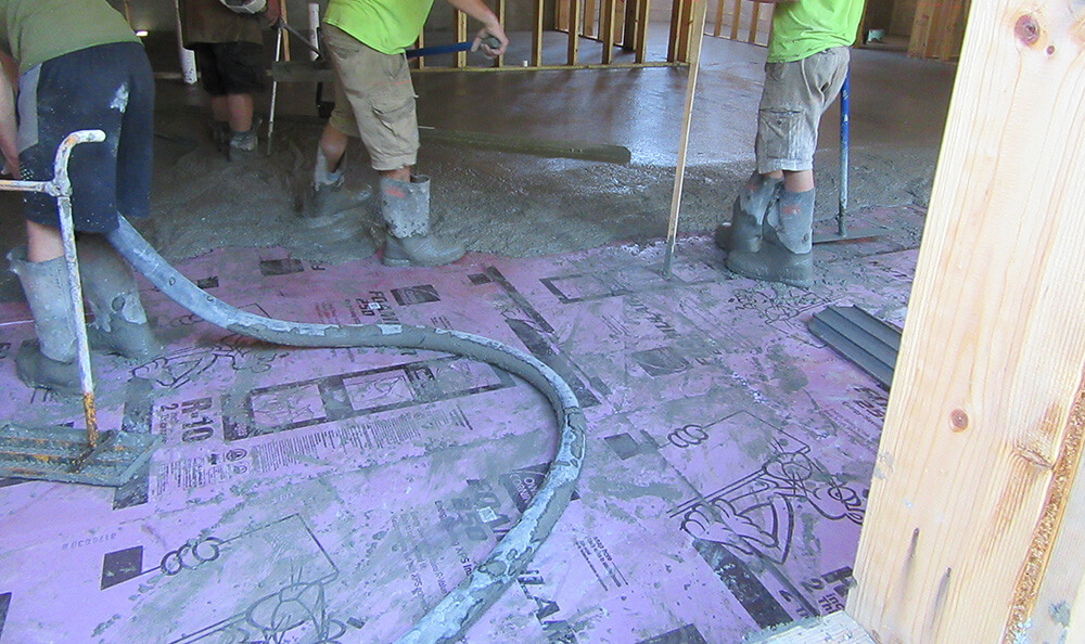 Continuous insulation being installed under the floor of a residential building project