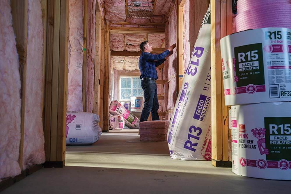 man installing Owens Corning® PINK Next Gen™ Fiberglas™ Insulation on wall