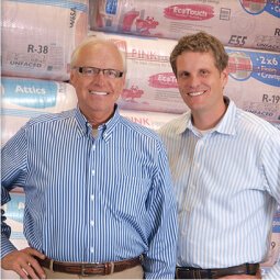 IDI founder and son standing in front of a palette of insulation