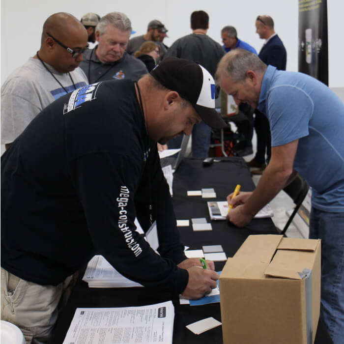 A group of people gathering and signing paperwork