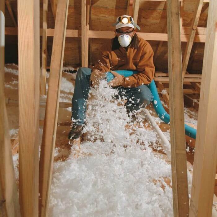 person using blown-in insulation
