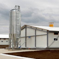 Silver silo next to white building