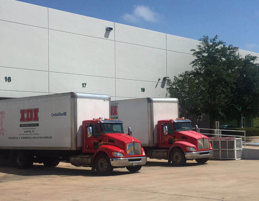 Two semis backed up to loading bay outside of IDI Austin branch