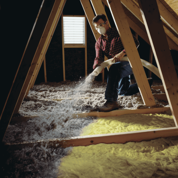 person using blower in attic