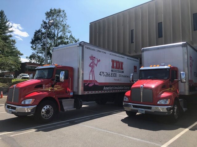 Two IDI trucks parked next to one another