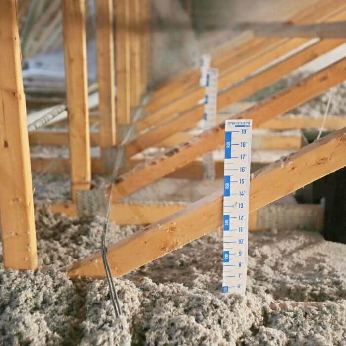 rulers sticking through old attic insulation