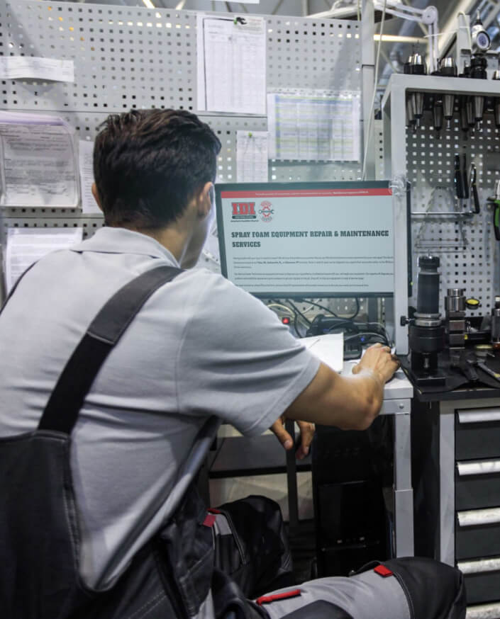 Man looking at spray foam equipment repair and maintenance services page on desktop computer