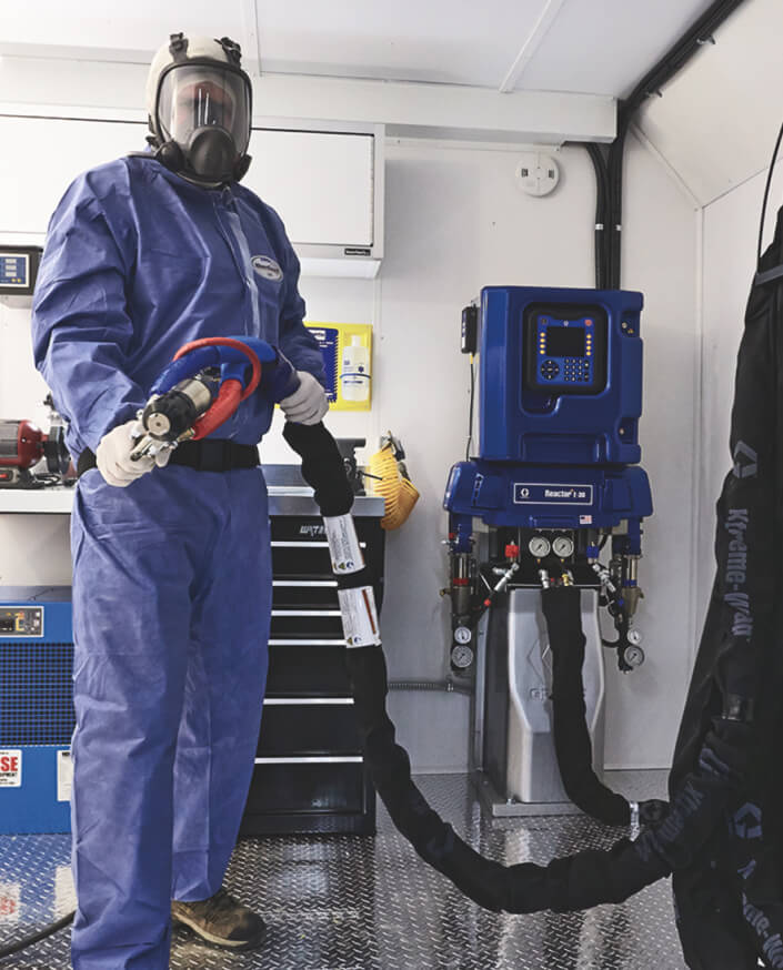 Man in full blue safety gear using insulation rig