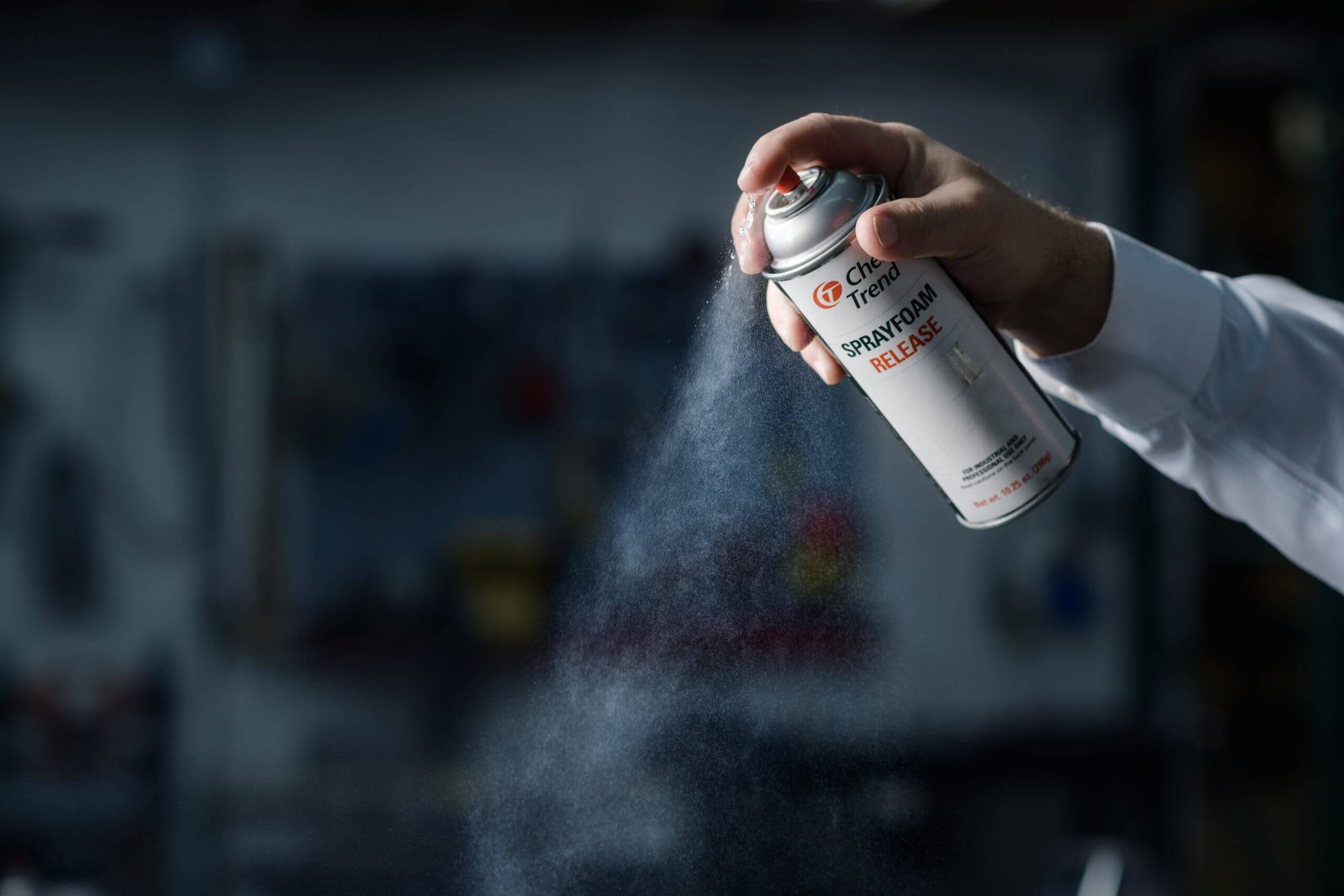 A hand spraying Chem-Trend Spray Foam Silicone from a canister.