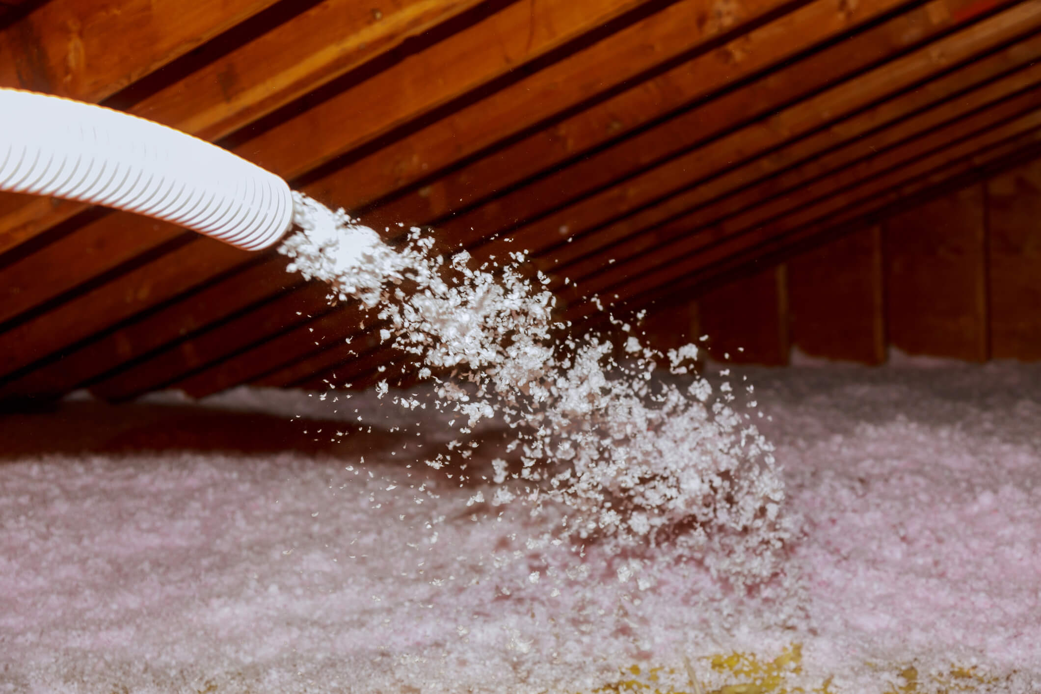 Insulation being sprayed into ceiling from tube