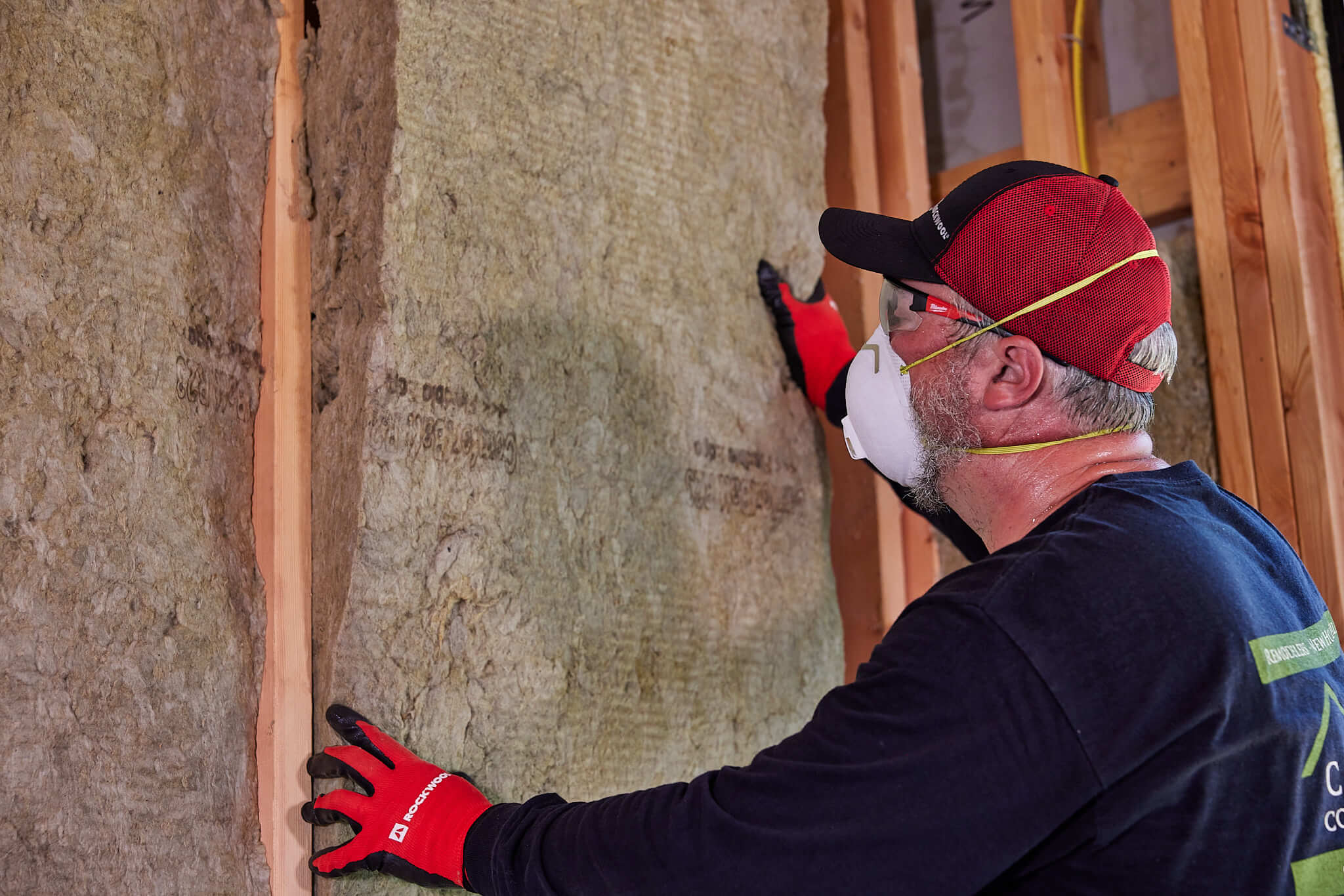 man installing fiberglass insulation