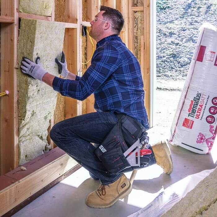 man installing Thermafiber ultrabatt insulation