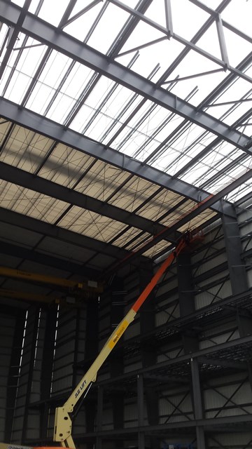 Natural light shining through ceiling of storage space with small crane