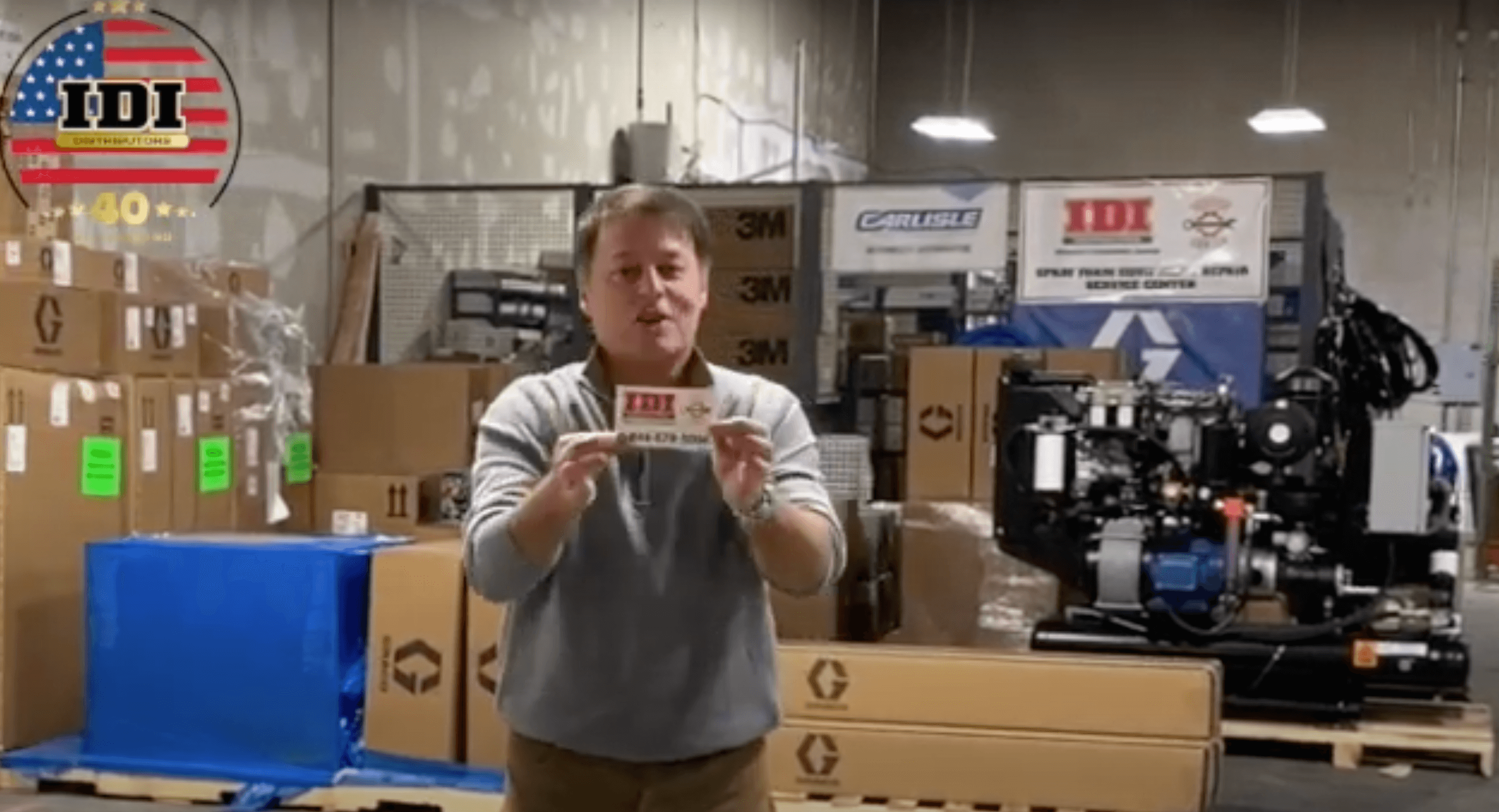 Man inside an IDI warehouse holding an IDI business card