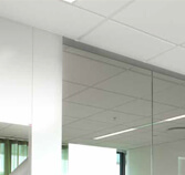 Image of glass wall meeting white paneled ceiling