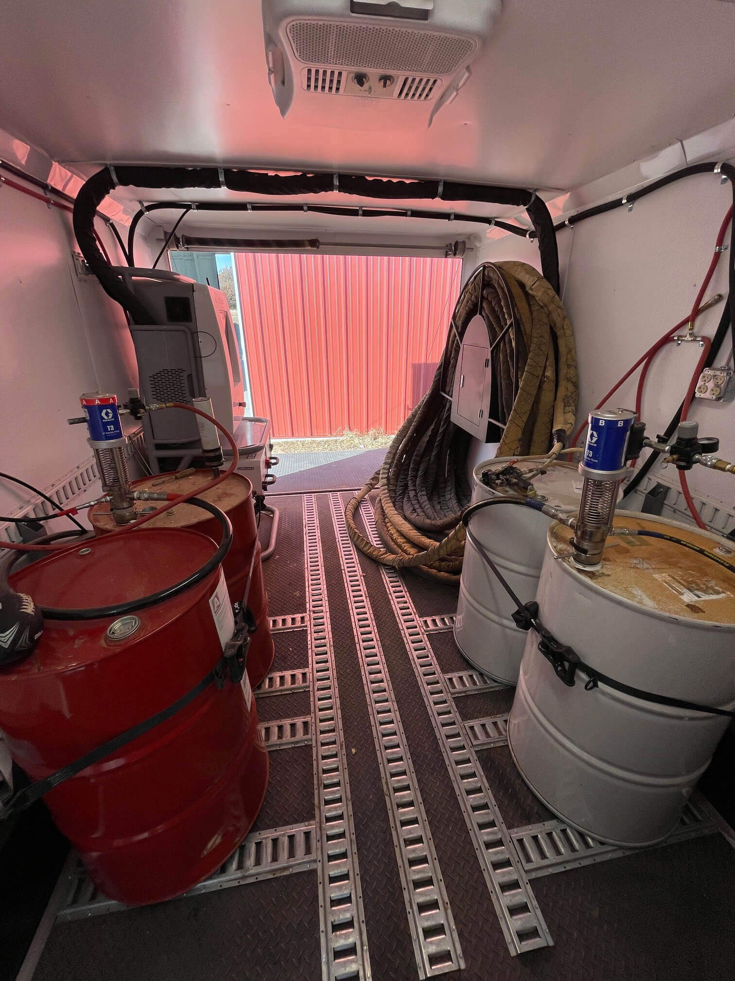 Inside of work truck featuring colored barrels and tubing