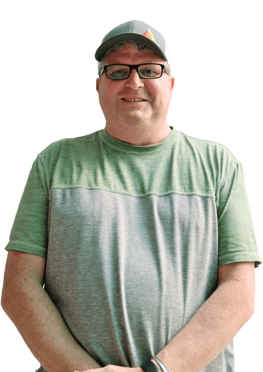 A white man in glasses, a hat and a green and gray shirt.