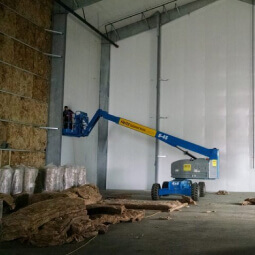 Worker on boom lift installing foam board